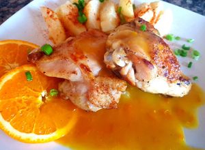 Una foto de Muslo corto de pollo con salsa de naranja y papas. 🍊