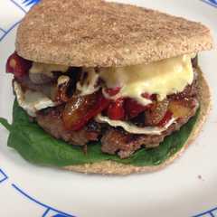 Una foto de Hamburguesa de ternera con queso de cabra y cebolla caramelizada con salsa de mostaza y curry