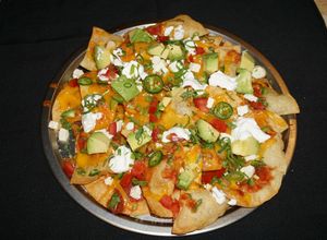 Una foto de NACHOS CON QUESO DE CABRA, PALTA Y CREMA AMARGA