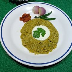 A picture of Palak Khichdi with broken rice and lentils.