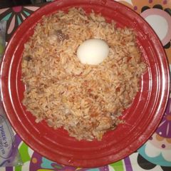 A picture of Jollof rice with boiled egg.