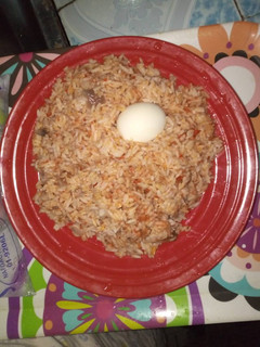 A picture of Jollof rice with boiled egg.