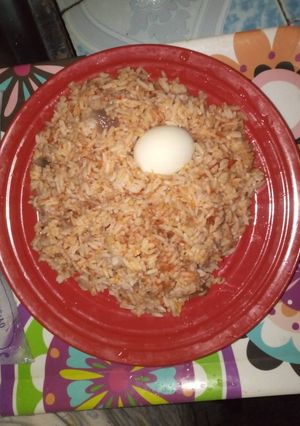 A picture of Jollof rice with boiled egg.