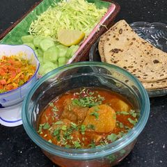 A picture of Aloo gosht salan with roti.