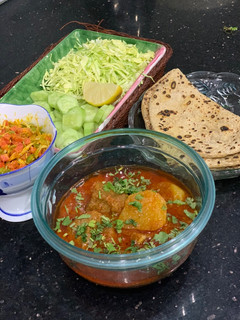 A picture of Aloo gosht salan with roti.