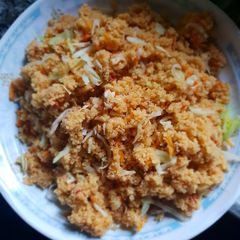 A picture of Jollof cous cous with shredded chicken.