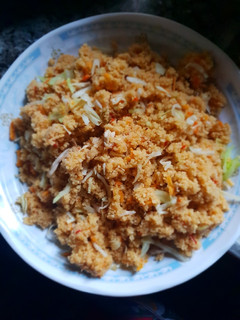A picture of Jollof cous cous with shredded chicken.
