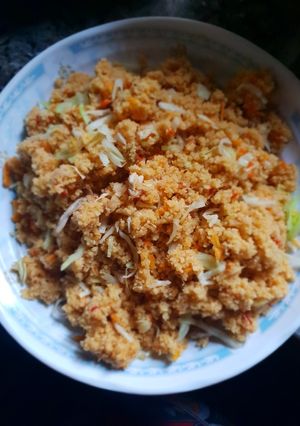 A picture of Jollof cous cous with shredded chicken.