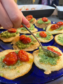Una foto de Blinis con pesto de brócoli y Tomates asados
