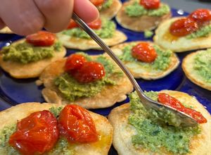 Una foto de Blinis con pesto de brócoli y Tomates asados