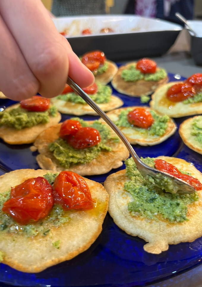 Una foto de Blinis con pesto de brócoli y Tomates asados
