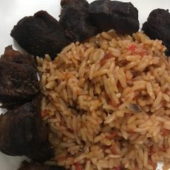 A picture of Jollof rice with fried beef.