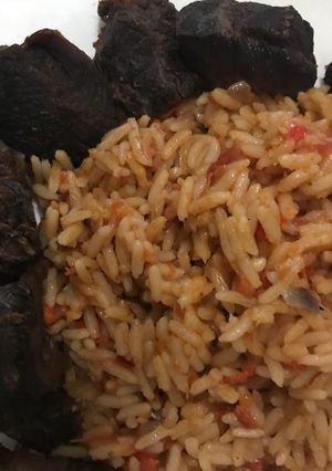 A picture of Jollof rice with fried beef.