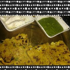A picture of Gobi Paratha with mint chutney.