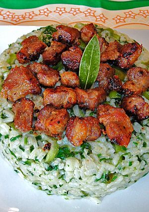 Una foto de Bomba de arroz verdoso con jamón de cerdo fritoal champán