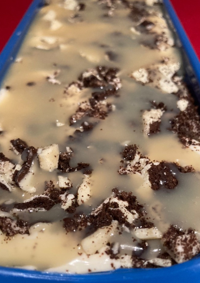 Una foto de Helado de chocolate blanco con galletas oreo de chocolate blanco y sirope de chocolate blanco