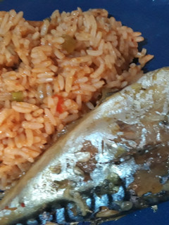A picture of Jollof rice with fried fish.