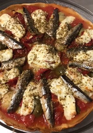 Une photo de Pizza maison tomates anchois poivrons artichauts mozzarella di buffala et câpres italiennes