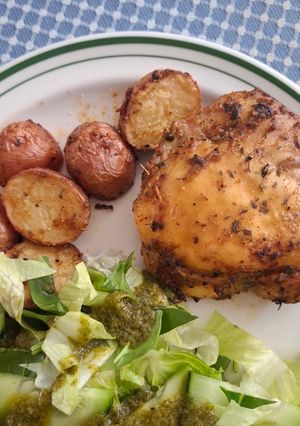 Una foto de Muslos con papas al horno