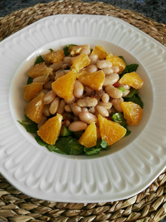 Una foto de Ensalada templada de alubias blancas, espinacas y naranja