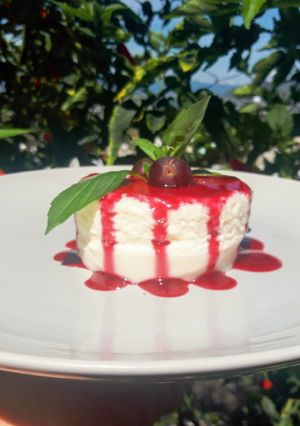 Una foto de Panna cotta de coco con coulis de Jamaica y mezcal