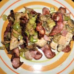A picture of Medallón de pollo con hongos y puerro en colchón de panceta crispy.
