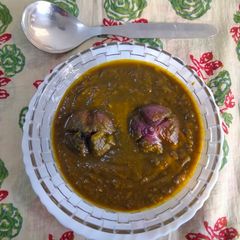 A picture of Whole onion in green leafy gravy.