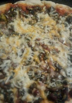 Una foto de Pizza con cerveza, carne picada de venado, espinacas, champiñones y beicon 