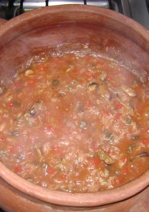 Una foto de Mariscos en salsa de tomate con arroz en olla de barro