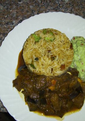A picture of Fried beef, vegetable rice with guacamole.