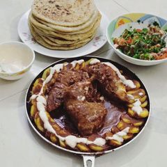 A picture of Chicken Gravy and Potato Paratha with Raita and Salad.