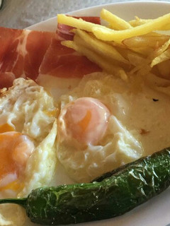 Una foto de Huevos fritos con patatas, pimiento y jamón