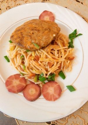 A picture of Orange Sauce Spaghetti with chicken patty.