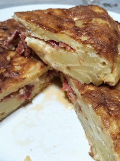 Una foto de Tortilla de papa, rellena con cantimpalo y queso mantecoso