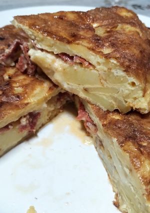 Una foto de Tortilla de papa, rellena con cantimpalo y queso mantecoso
