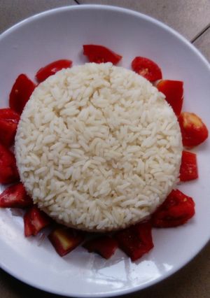 A picture of White rice and fresh tomatoes.
