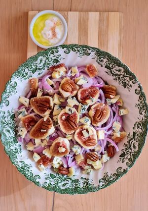 Una foto de Ensalada de higos negros, cebolla morada, queso azul con pecanas