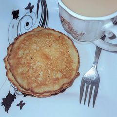 A picture of Banana pancakes served with ginger tea.