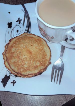 A picture of Banana pancakes served with ginger tea.