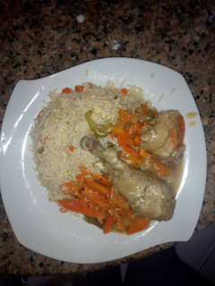 A picture of Stirred white rice and chicken sauce.