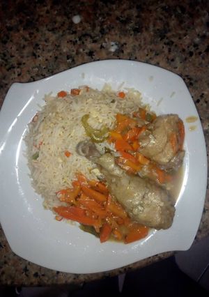 A picture of Stirred white rice and chicken sauce.