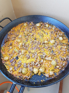 Una foto de Paella de pato, ajos tiernos, espárragos verdes y alcachofas