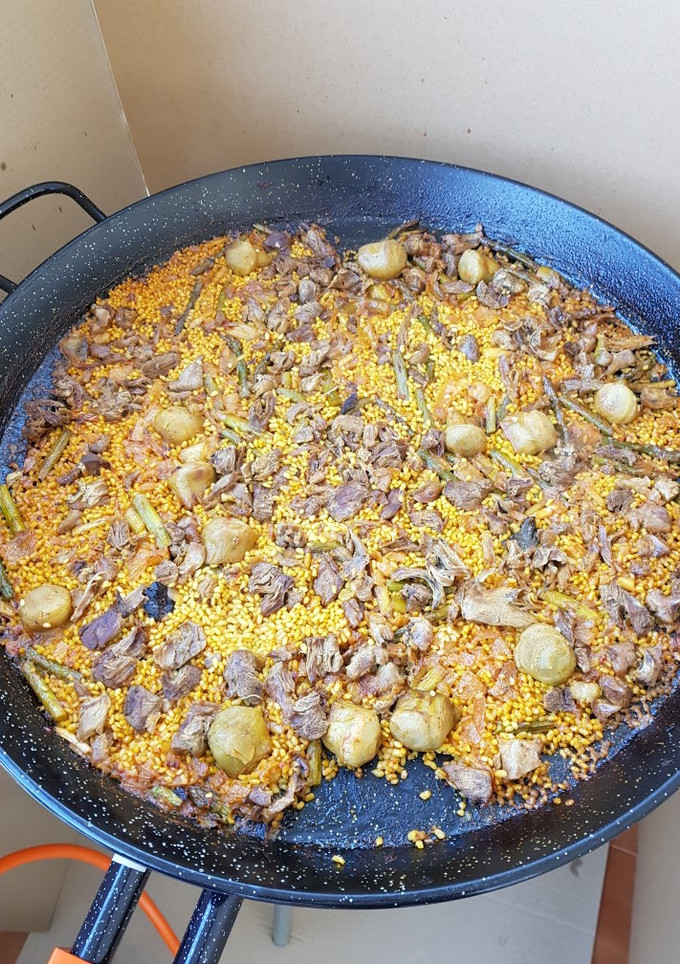 Una foto de Paella de pato, ajos tiernos, espárragos verdes y alcachofas