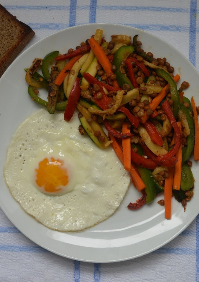 Una foto de Salteado de verduras y lentejas y huevo a la plancha