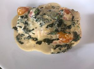 Una foto de Salmón con salsa de espinacas y tomate cherry