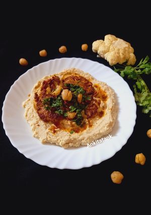 A picture of Grilled Cauliflower with Hummus and Chimichurri.