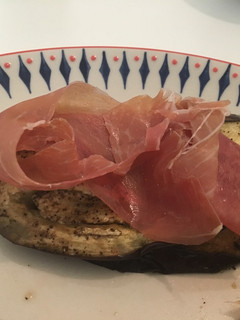 Una foto de Berenjena y tomate asado con jamón serrano