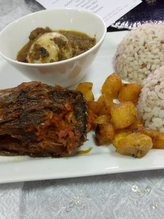 A picture of Ofada rice and sauce with fried plantain amd peppered fish.