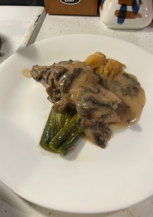 A picture of Mushroom cream sauce over braised chicken and leeks.
