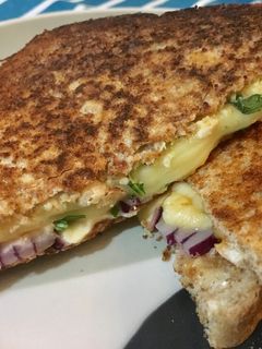 Una foto de Sándwich tostado de pollo, mostaza, rúcula, queso